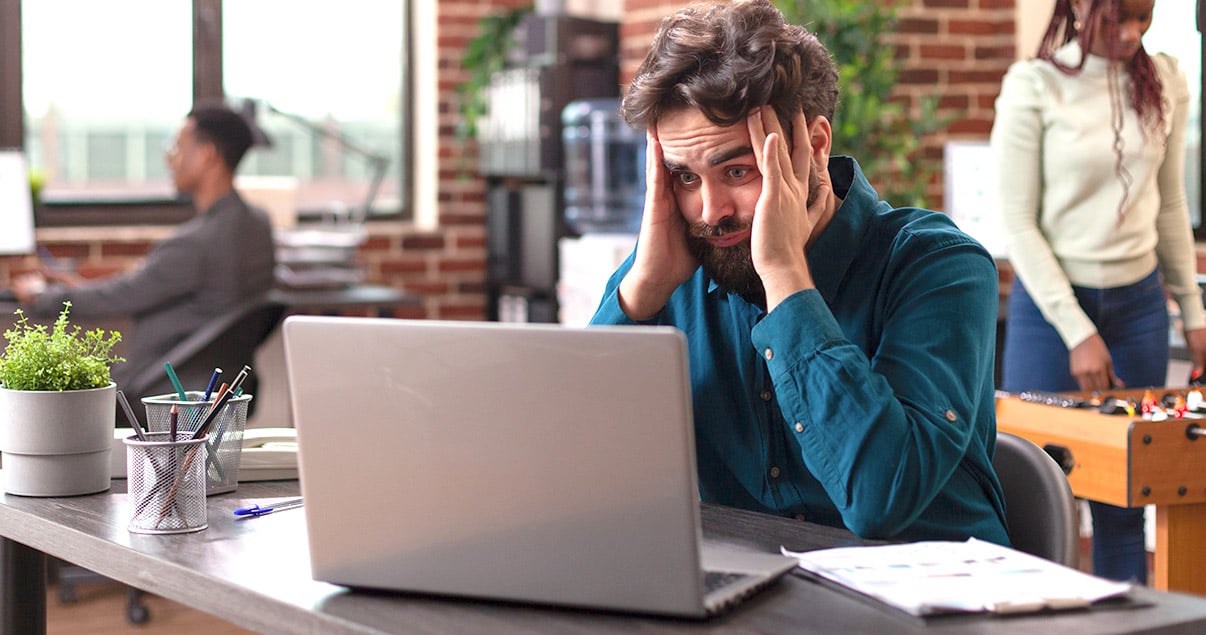 Hombre indeciso mirando su computadora