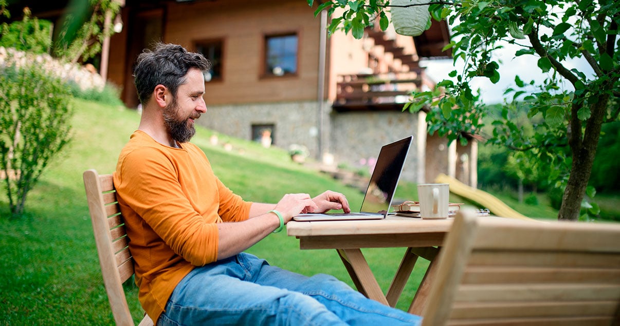 Hombre haciendo homeoffice en un jardín