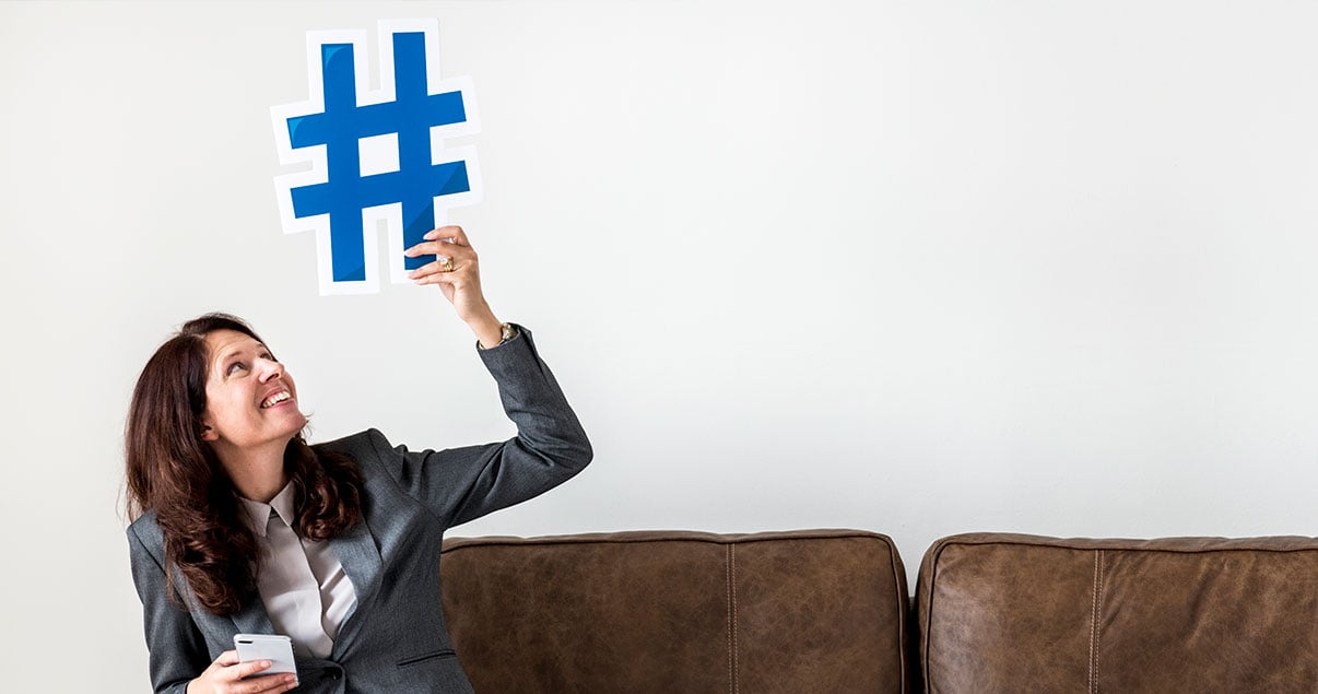 Agente inmobiliaria sosteniendo cartel de hashtag