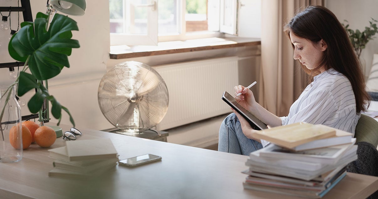 Mujer sentada escribiendo cómoda en su casa