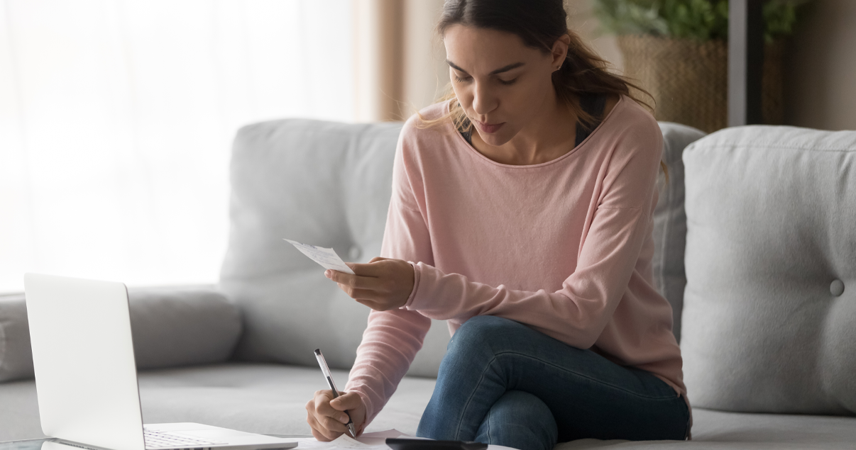 Mujer tomando nota y pagando sus facturas de manera online